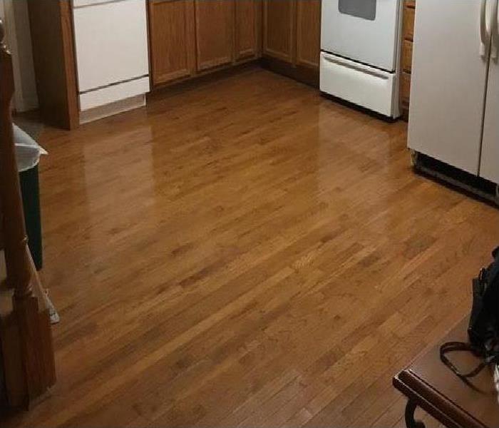 water covering wood flooring in kitchen