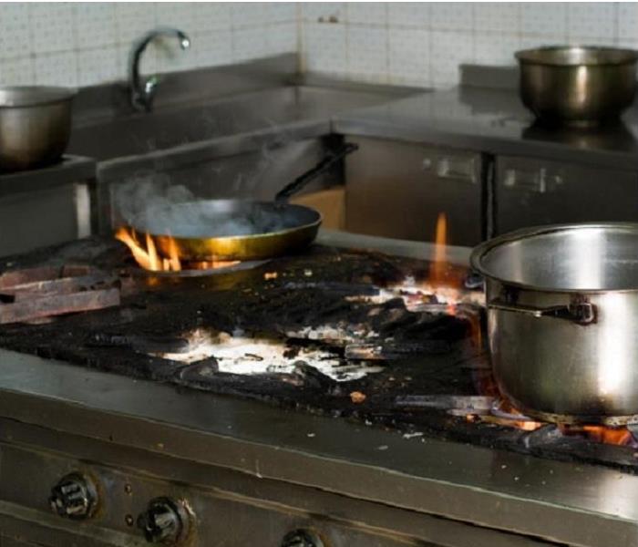 grease fire on stove, pans burning, soot residue on stove