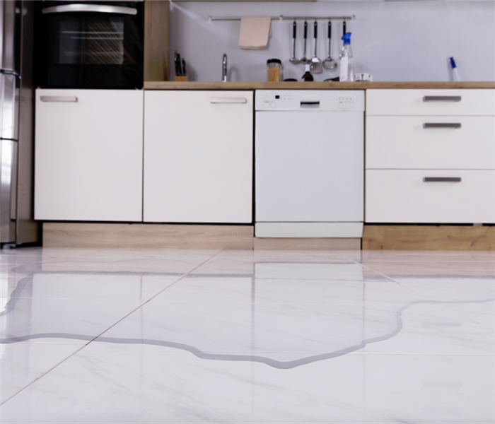 water covering the white tile floor in a kitchen
